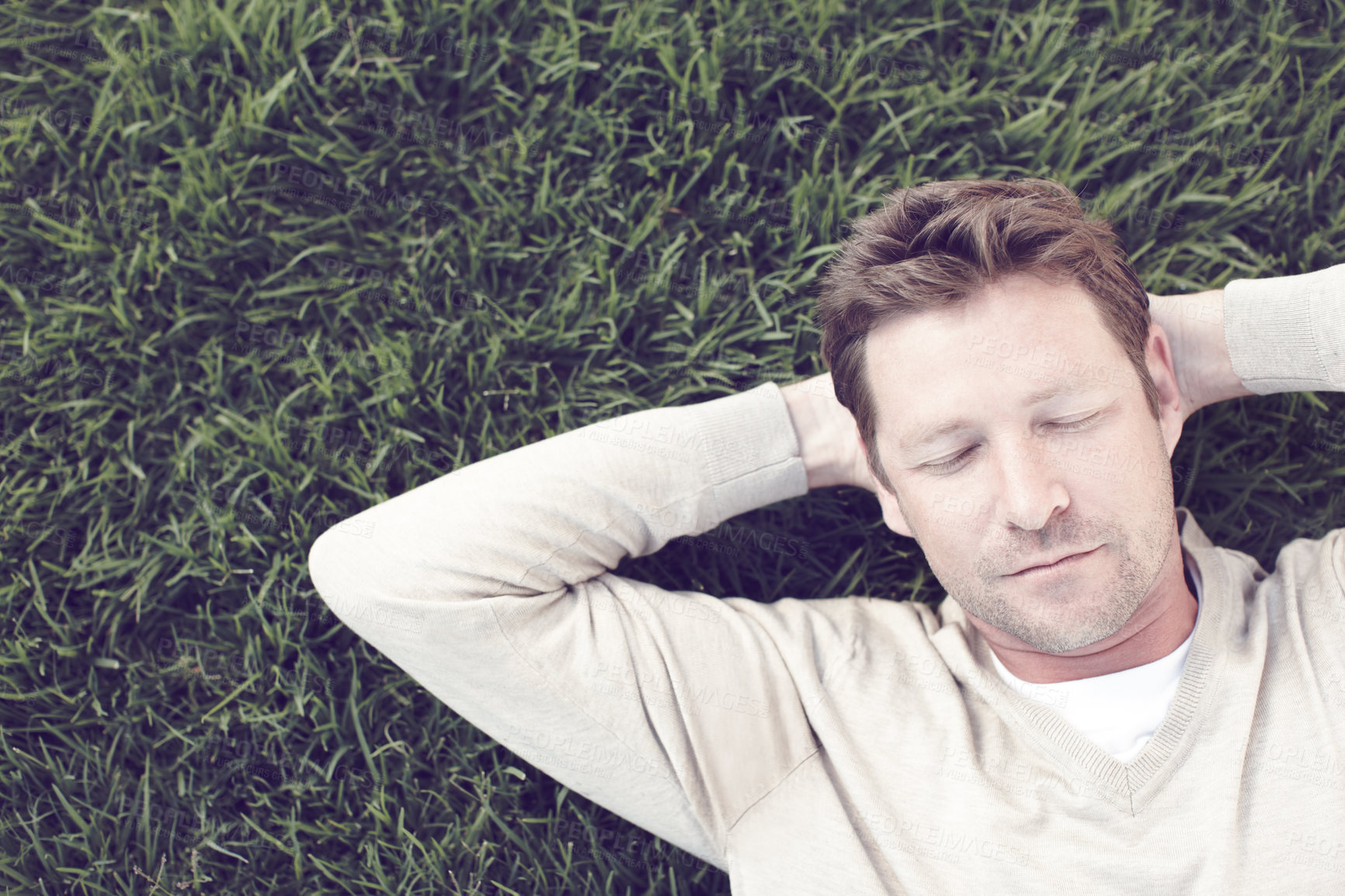 Buy stock photo Man, relax and sleeping on grass outdoor for resting, afternoon nap and exhausted in backyard. Calm person, face and dreaming on lawn at park with fatigue, tired and break with top view in nature