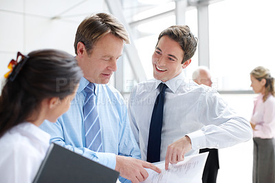 Buy stock photo Observant business executives going through documents together in an informal meeting 