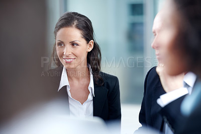 Buy stock photo Attractive businesswoman sitting in a meeting with her coworkers