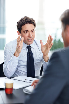 Buy stock photo Focused young businessman having a discussion during a meeting