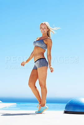 Buy stock photo Shot of a young woman working out on a sunny patio with a bosu ball