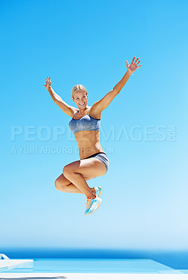 Buy stock photo Shot of a young woman in workout gear jumping in the air