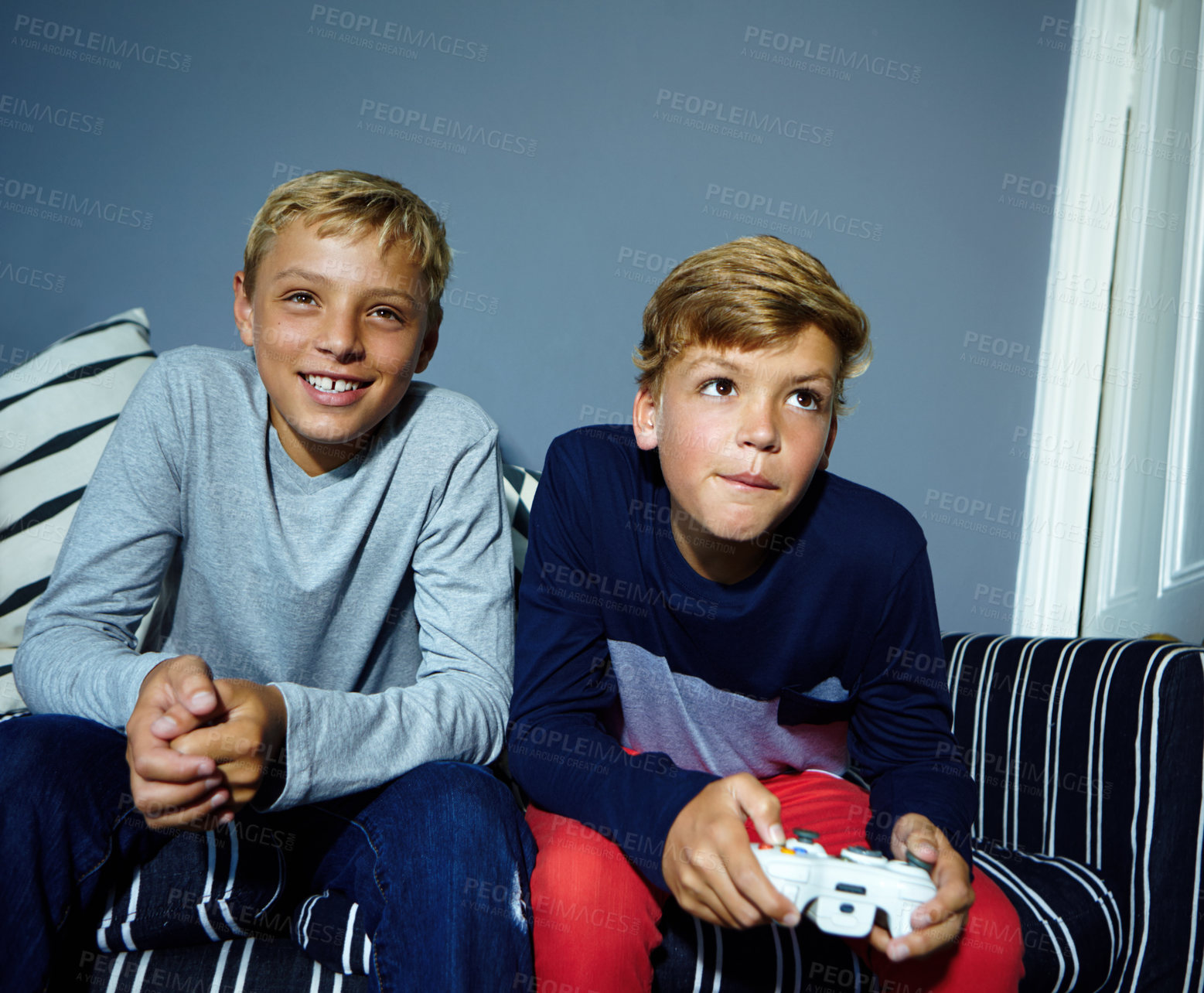 Buy stock photo Shot of young boys playing video games