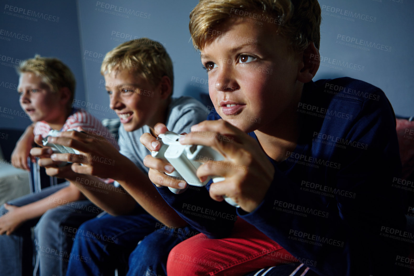 Buy stock photo Shot of young boys playing video games