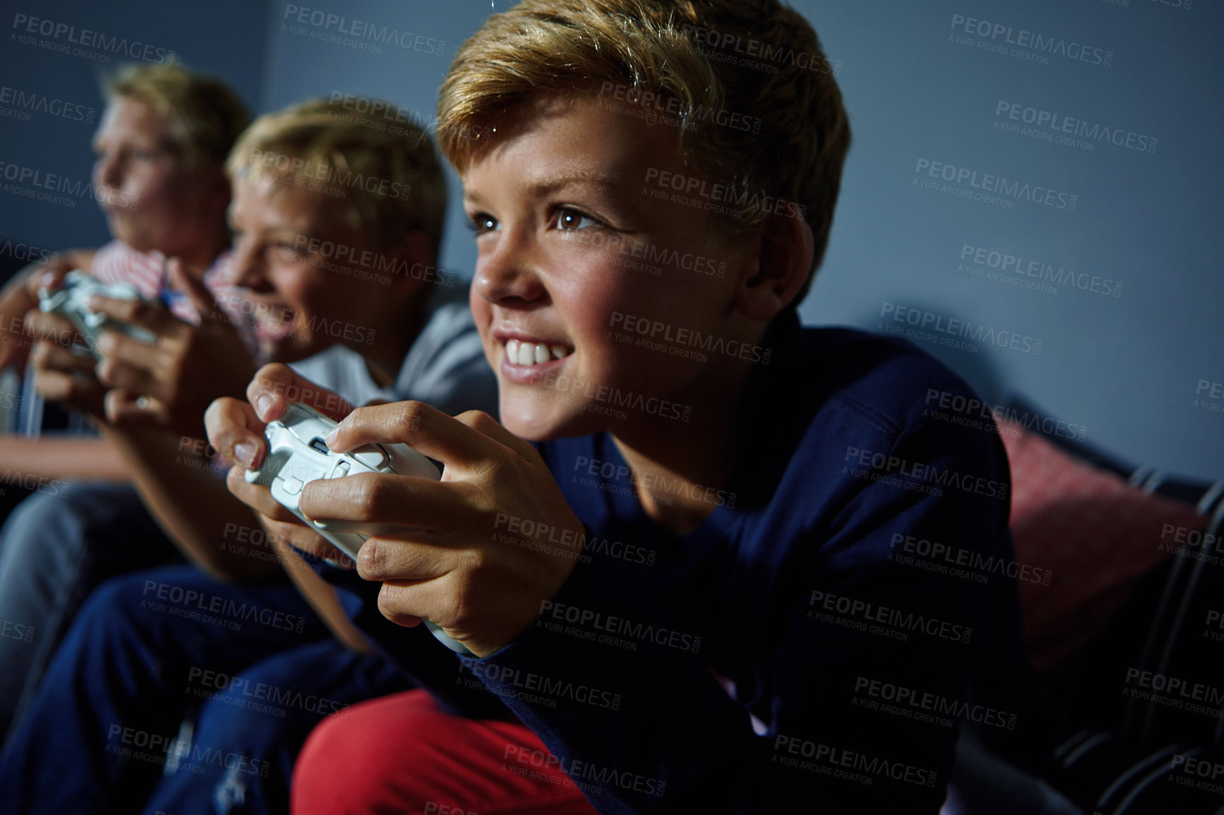 Buy stock photo Shot of young boys playing video games