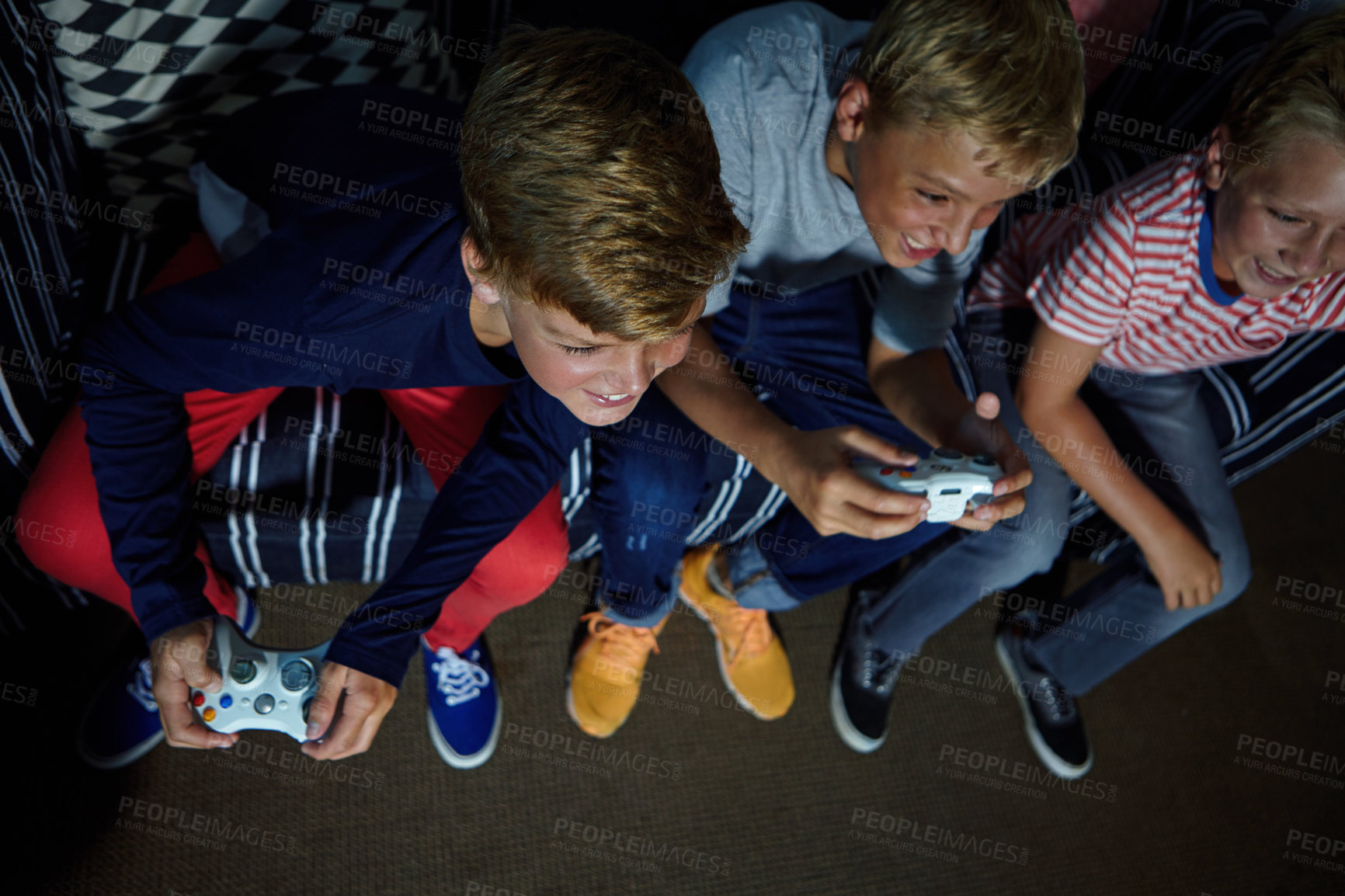 Buy stock photo Shot of young boys playing video games