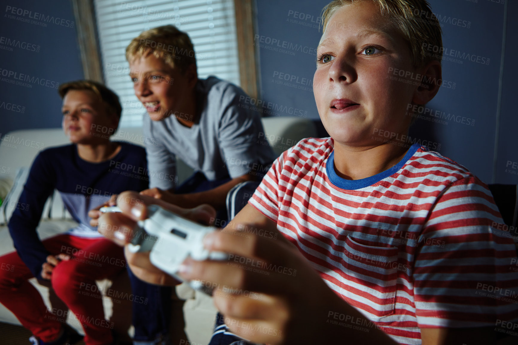 Buy stock photo Shot of young boys playing video games