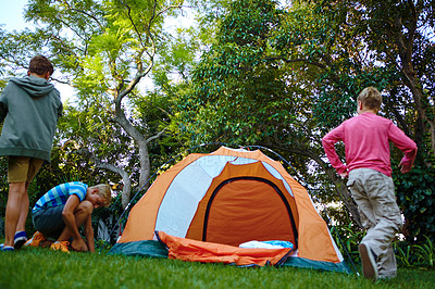 Buy stock photo Shot of three young boys putting up their tent