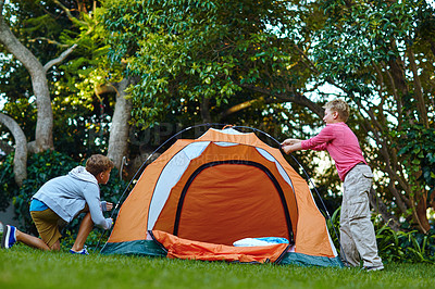 Buy stock photo Shot of two young boys putting up their tent