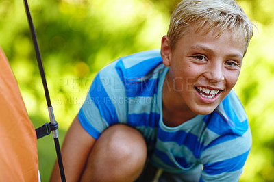 Buy stock photo Cropped portrait of a young boy putting up his tent