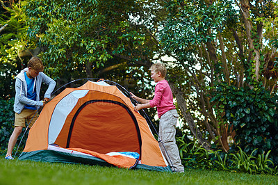 Buy stock photo Shot of two young boys putting up their tent