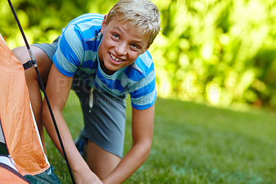 Buy stock photo Cropped portrait of a young boy putting up his tent