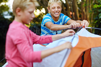 Buy stock photo Shot of two young boys putting up their tent