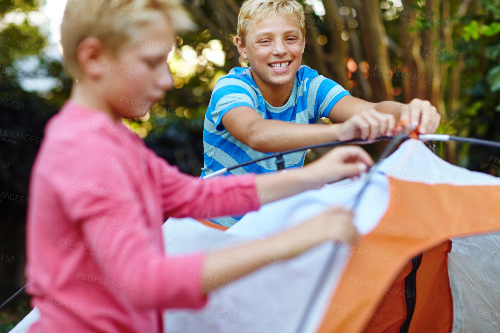 Buy stock photo Shot of two young boys putting up their tent