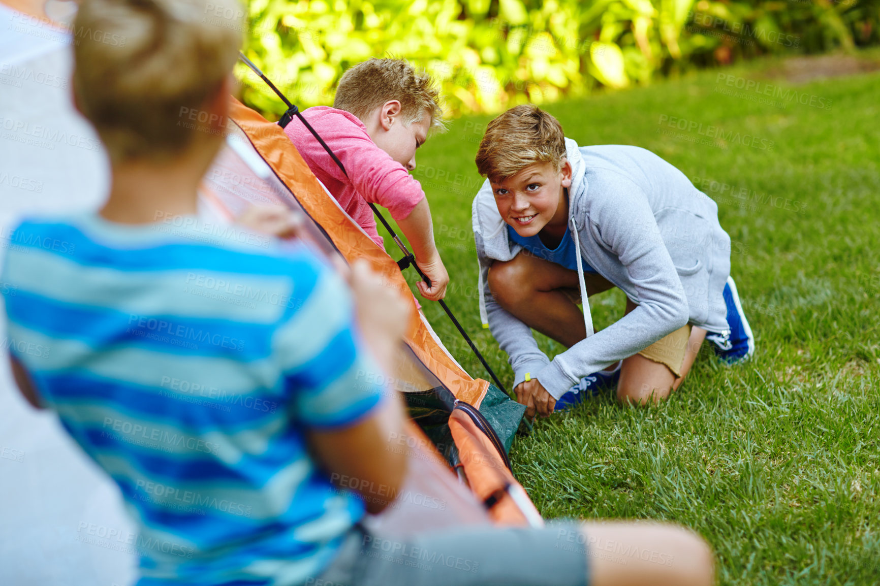 Buy stock photo Shot of three young boys putting up their tent