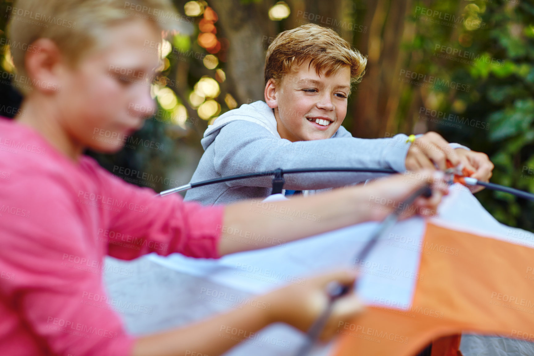 Buy stock photo Shot of two young boys putting up their tent