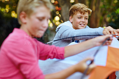 Buy stock photo Shot of two young boys putting up their tent