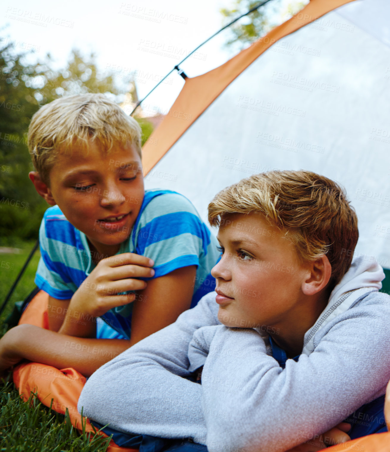 Buy stock photo Cropped shot of three young boys lying in their tent