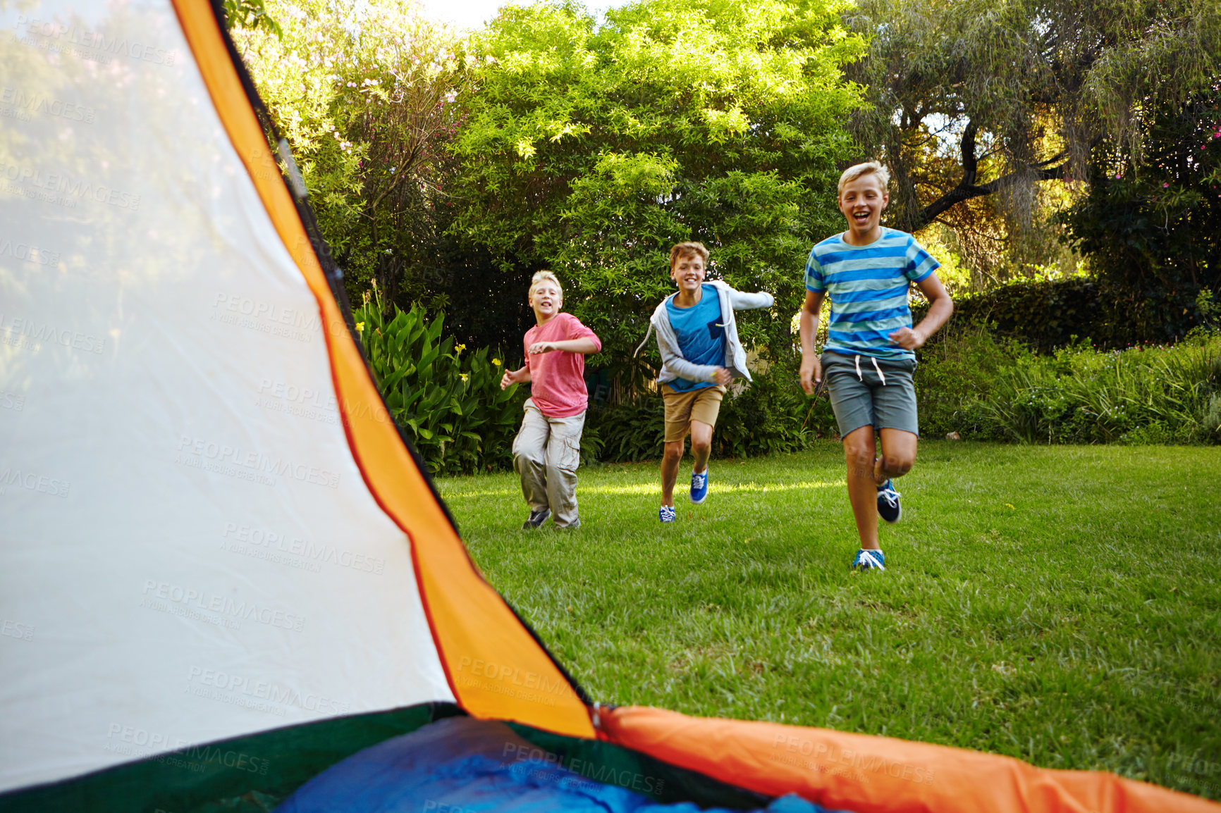 Buy stock photo Full length shot of three young boys running into their tent