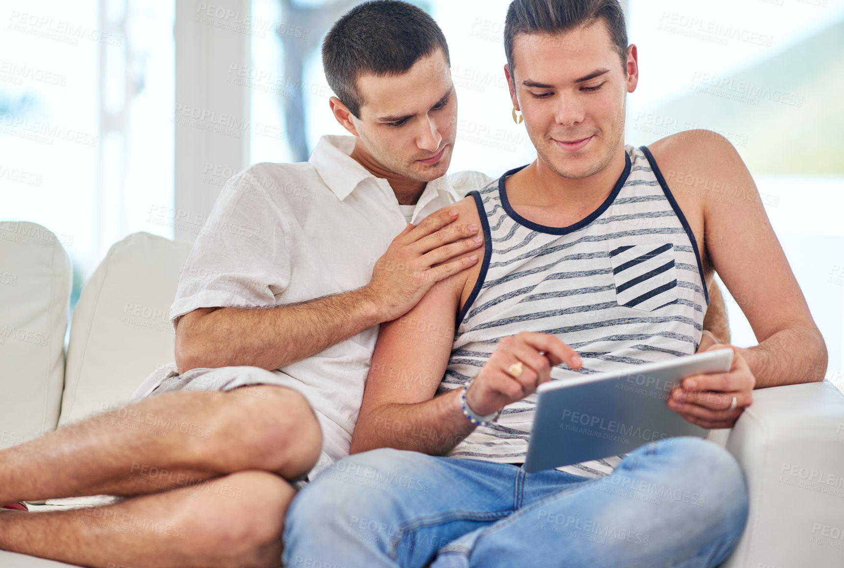 Buy stock photo Gay couple, relax and tablet on sofa for social media, streaming and online shopping in home. Men, partners and technology in living room for browsing, connectivity and latest LGBT news on internet