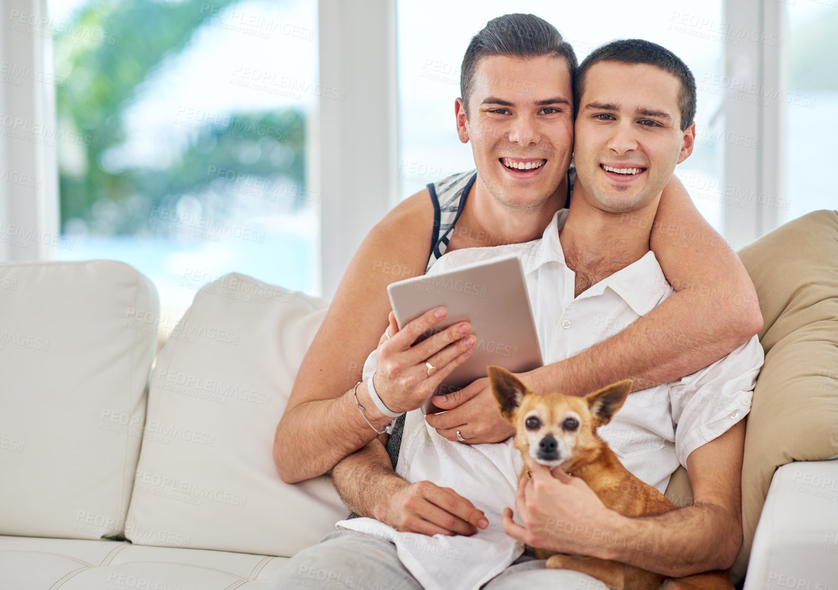 Buy stock photo Portrait of an affectionate gay couple relaxing on the sofa with their dog