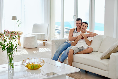 Buy stock photo Portrait of a young gay couple relaxing on a sofa at home