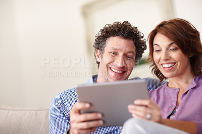 Buy stock photo Shot of a couple using a tablet  while relaxing at home