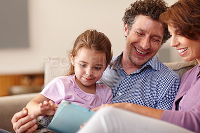 Buy stock photo Shot of a little girl using a digital tablet white sitting with her parents