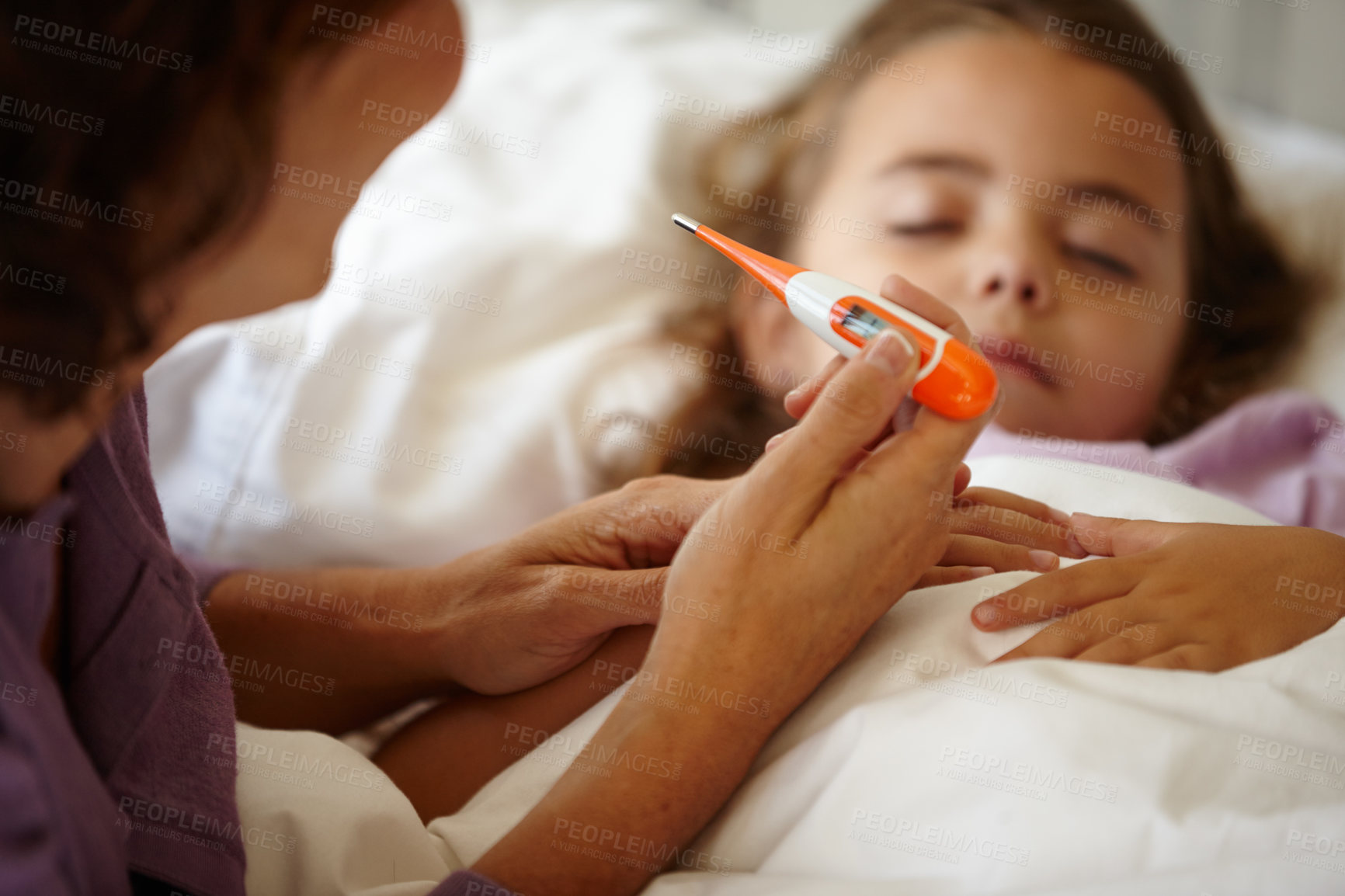 Buy stock photo Shot of a little girl lying in bed while her mother takes her temperature with a thermometer