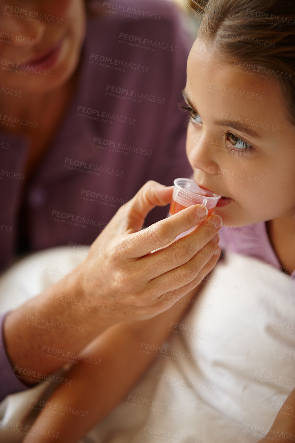 Buy stock photo Shot of a mother giving her daughter medicine