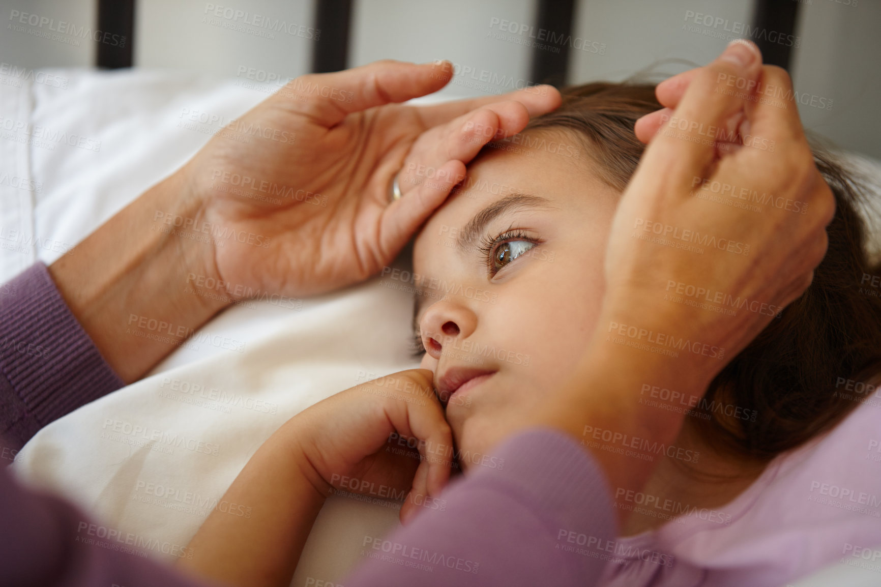 Buy stock photo Shot of a caring mother feeling the forehead of her sick little girl