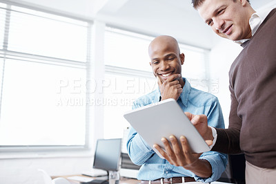 Buy stock photo Two business colleagues using a digital tablet in the office
