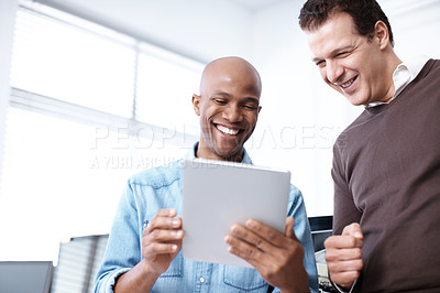 Buy stock photo Two business colleagues working on a digital tablet in the office