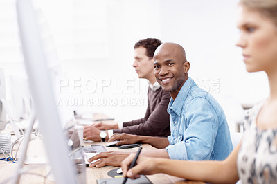 Buy stock photo Portrait of three business colleagues working hard on the computers in the office