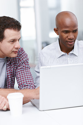 Buy stock photo Two architects looking at a computer screen while seated at a desk