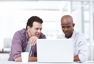Buy stock photo Two professionals working together on a project on a laptop while sitting at a table