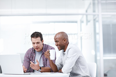 Buy stock photo Two businessmen working together on a project while sitting at a desk with a laptop