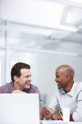 Buy stock photo Two businessmen having a discussion while they're seated at a table with a laptop