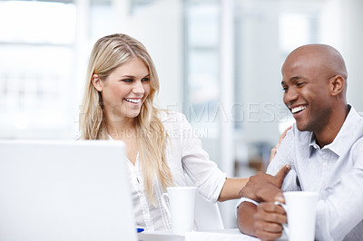 Buy stock photo Two young businesspeople working together on a project