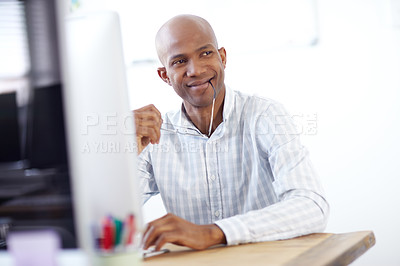 Buy stock photo Shot of a thougtful-looking african american designer sitting in his chair in front of a desktop computer in the office