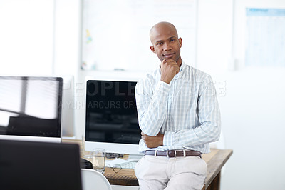 Buy stock photo Portrait of a thoughtful-looking african american businessman leaning against a desk lined with computers