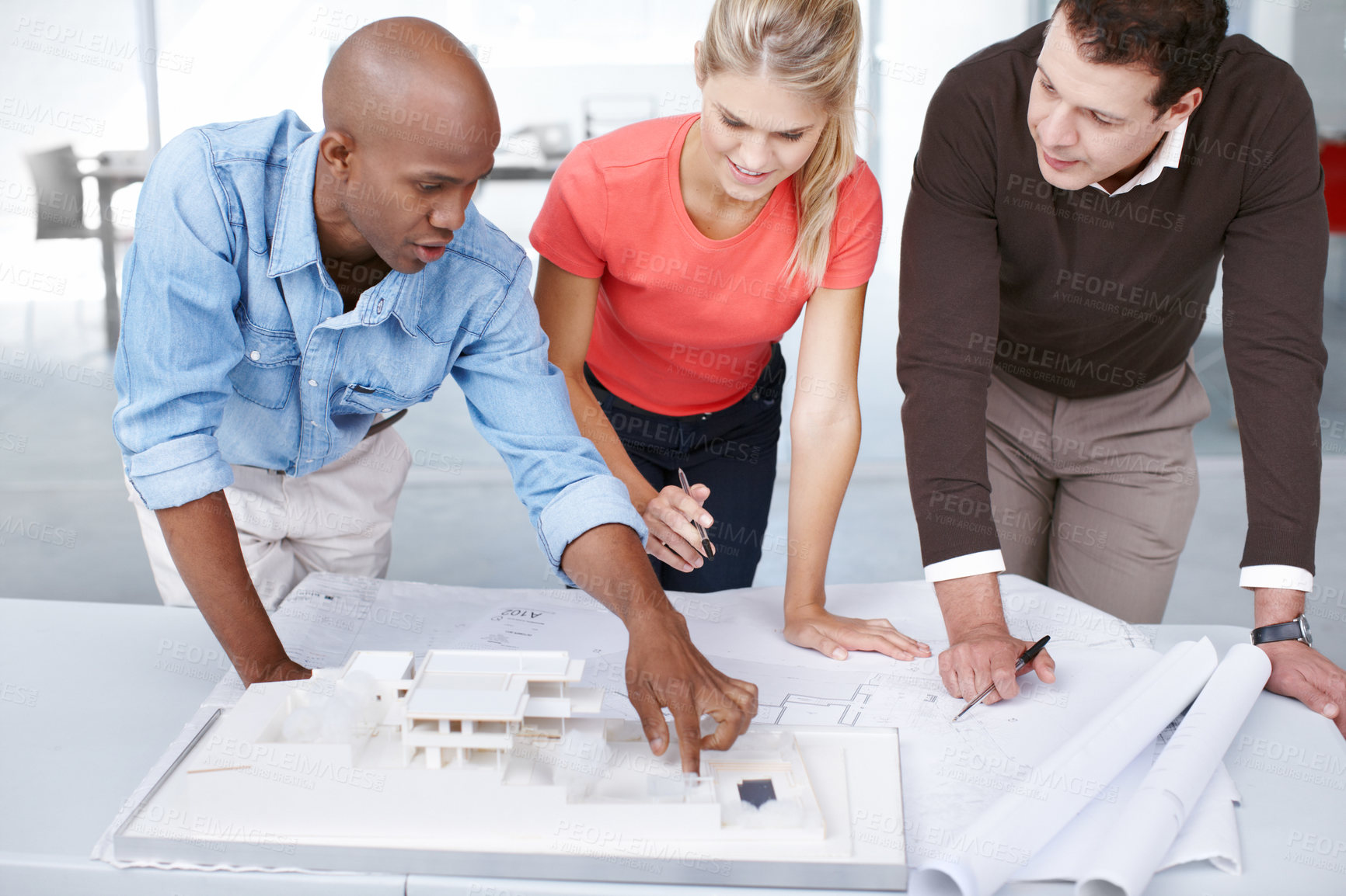 Buy stock photo Three architects discussing their architectural model