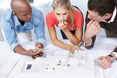 Buy stock photo A group of architects working together on an architectural model