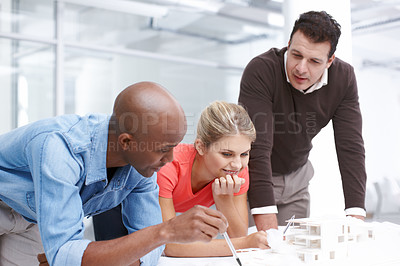 Buy stock photo A team of architects working together on an architectural model