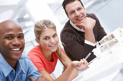 Buy stock photo Portrait of a team of cheerful architects sitting by their architectural model