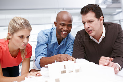 Buy stock photo Three architects working together on an architectural model