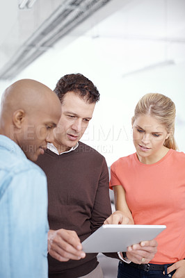 Buy stock photo Three businesspeople using a digital tablet in the office
