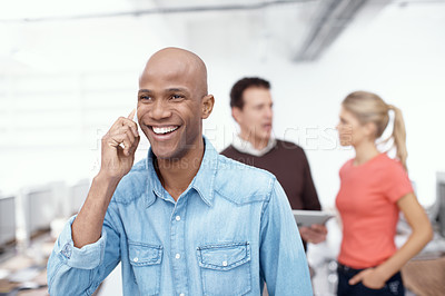 Buy stock photo A young businessman talking on his mobile in the office
