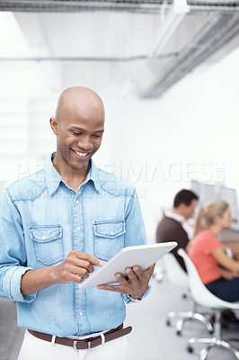Buy stock photo A young businessman working on a digital tablet in the office