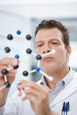 Buy stock photo A scientist looking at a molecular structure model